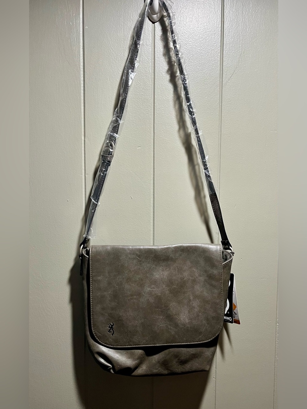 Browning Sierra crossbody bag features a gray faux leather finish and a signatur